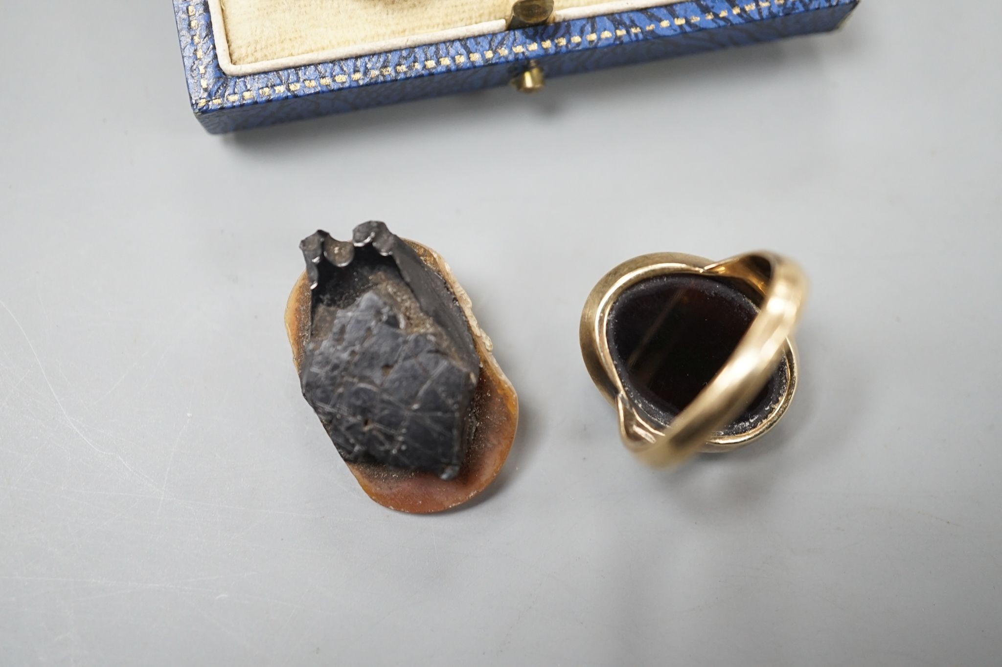 A yellow metal and hardstone set cameo ring, size J (a.f.), gross 6.9 grams, a pair of similar cameo shell ear clips and one other cameo shell mount.